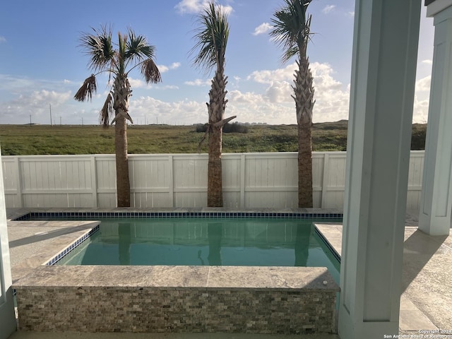 view of swimming pool with a rural view