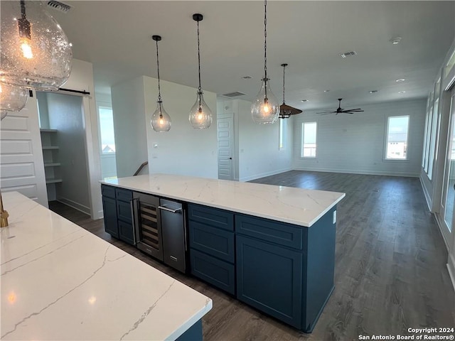 kitchen with a barn door, a center island, and dark hardwood / wood-style floors