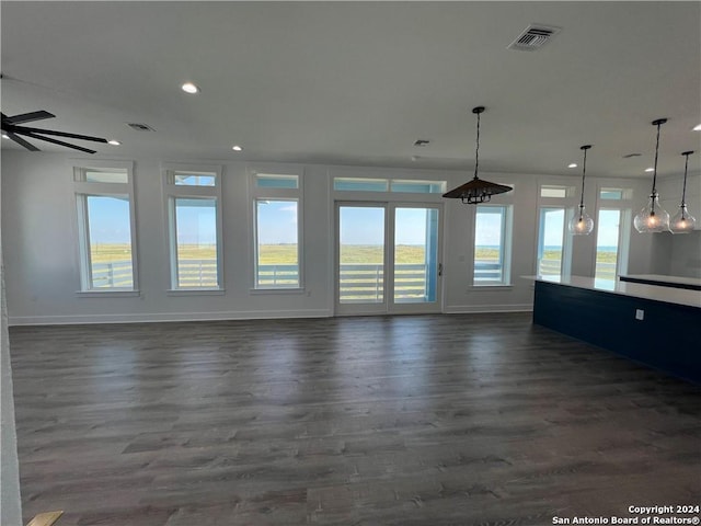 unfurnished living room featuring ceiling fan and dark hardwood / wood-style flooring