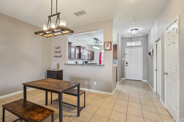 dining area featuring light tile patterned floors and a notable chandelier