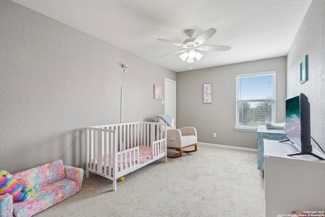 bedroom with a textured ceiling, light colored carpet, and ceiling fan