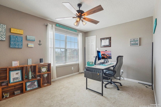 carpeted office featuring ceiling fan and a textured ceiling