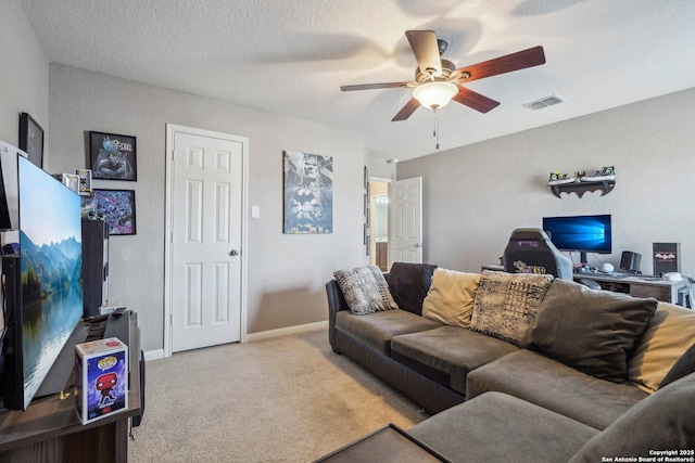 living room featuring light colored carpet, a textured ceiling, and ceiling fan