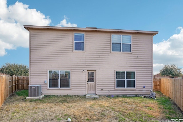 back of property featuring central AC unit and a lawn