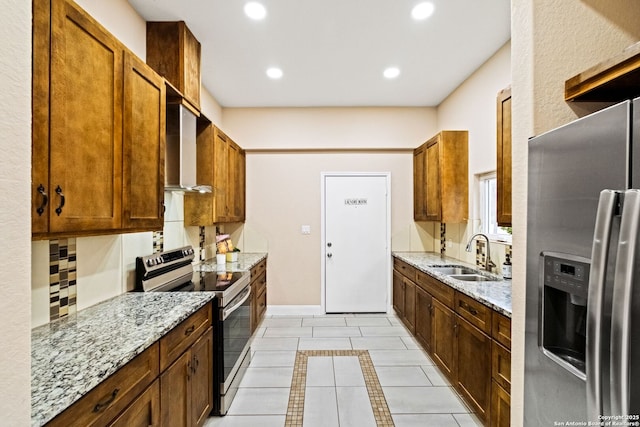 kitchen featuring sink, light stone countertops, wall chimney exhaust hood, and appliances with stainless steel finishes