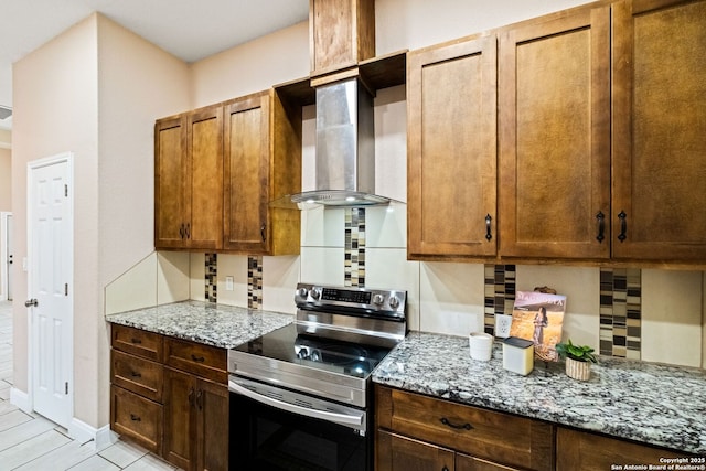 kitchen featuring tasteful backsplash, stainless steel range with electric stovetop, light stone countertops, and wall chimney range hood