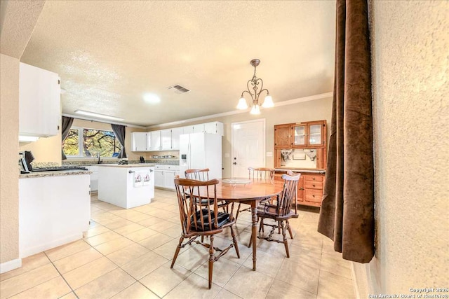 tiled dining room with ornamental molding, a textured ceiling, and a chandelier