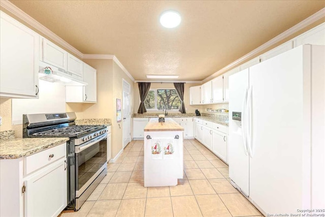 kitchen featuring gas range, white fridge with ice dispenser, white cabinets, and a center island