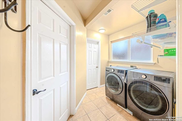 laundry room with washer and dryer and light tile patterned floors