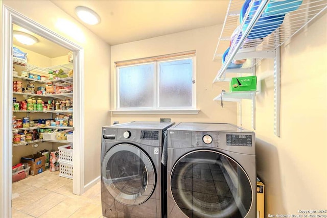 clothes washing area featuring light tile patterned flooring and separate washer and dryer