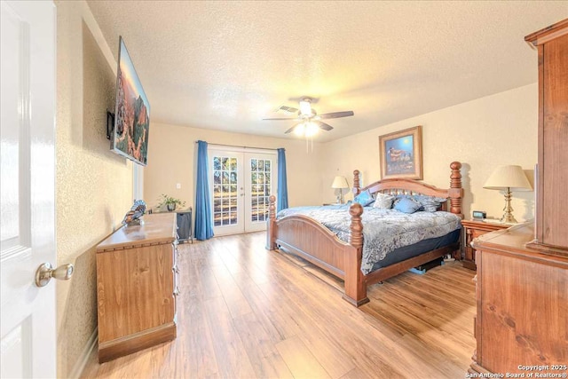 bedroom featuring access to exterior, light hardwood / wood-style flooring, french doors, and a textured ceiling