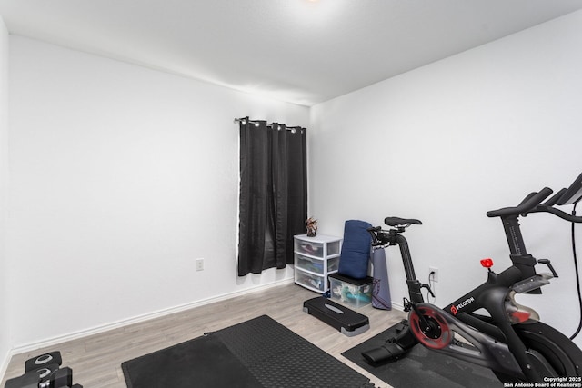 exercise room with light hardwood / wood-style floors