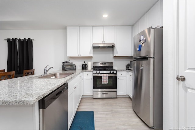 kitchen with stainless steel appliances, white cabinetry, and kitchen peninsula