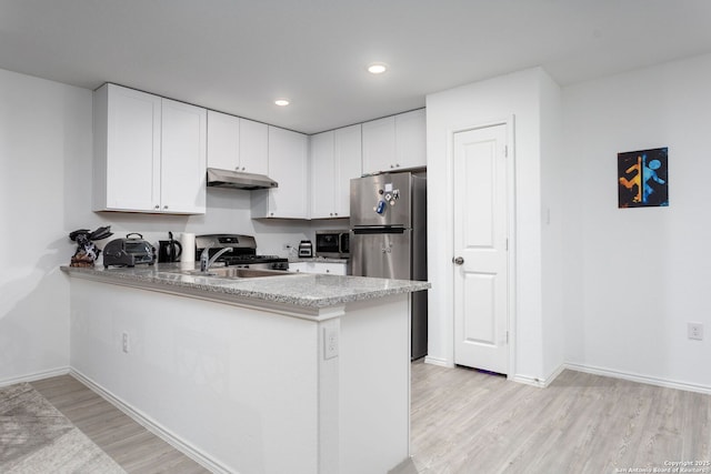 kitchen with white cabinetry, light hardwood / wood-style floors, kitchen peninsula, and appliances with stainless steel finishes