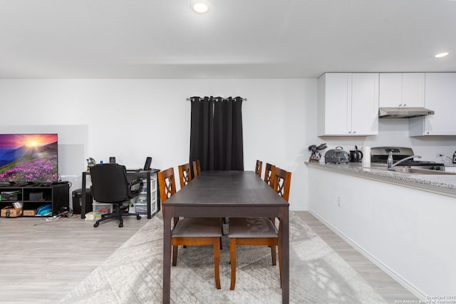 dining room featuring sink and light hardwood / wood-style floors