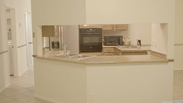 kitchen with light tile patterned floors, light brown cabinetry, sink, and black appliances