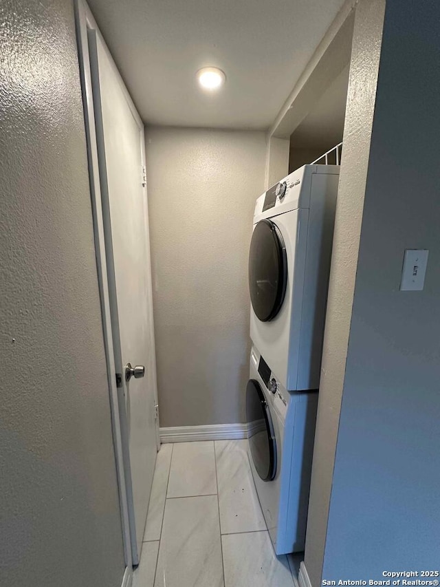 clothes washing area featuring stacked washer and dryer