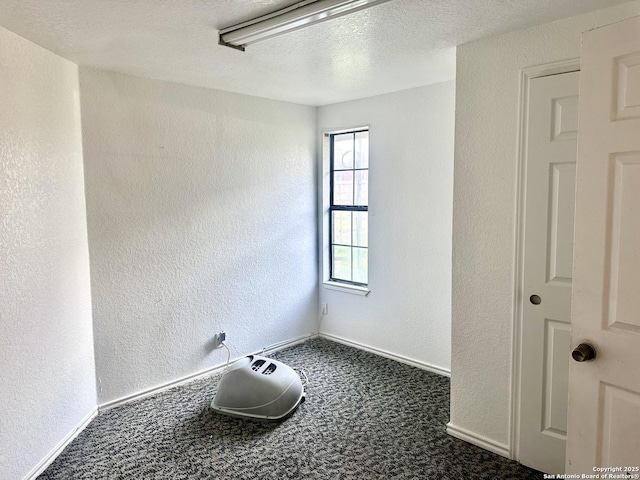 carpeted empty room with a textured ceiling