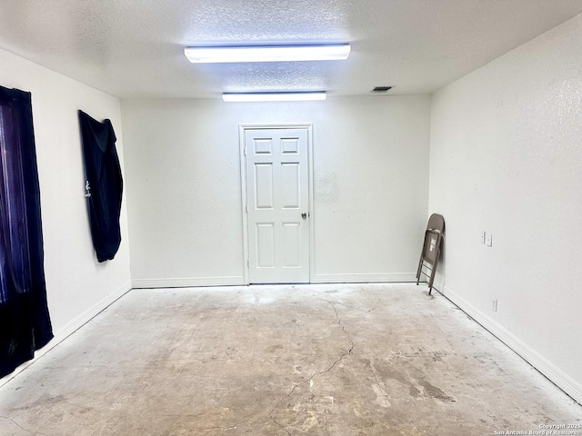 unfurnished room with a textured ceiling