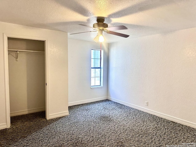 unfurnished bedroom featuring ceiling fan, a textured ceiling, dark carpet, and a closet