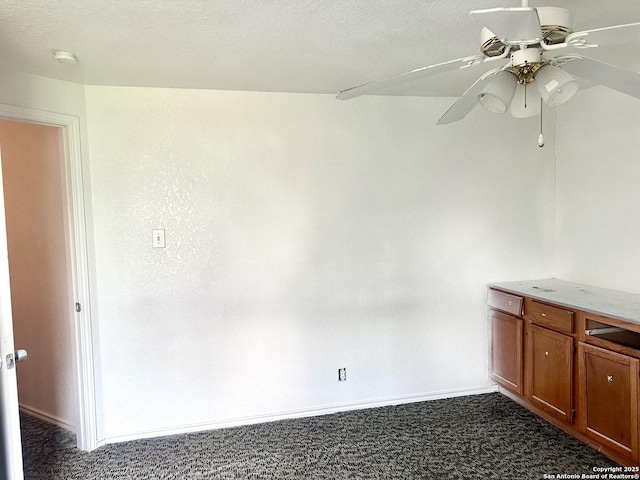 carpeted spare room featuring a textured ceiling and ceiling fan