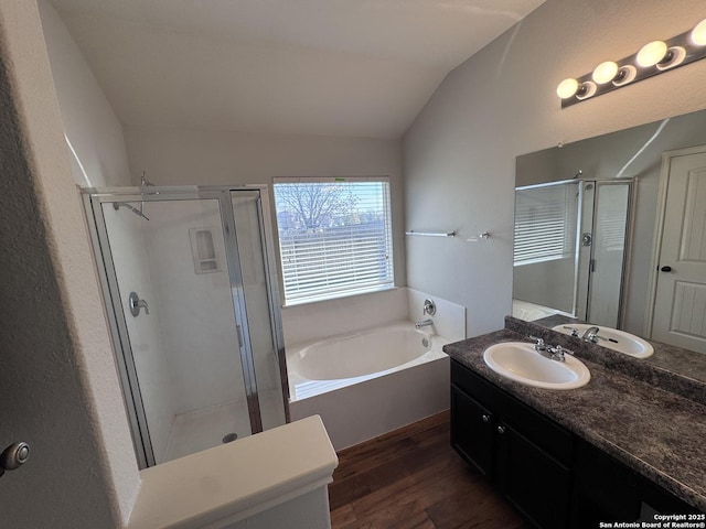 bathroom featuring hardwood / wood-style flooring, lofted ceiling, plus walk in shower, and vanity