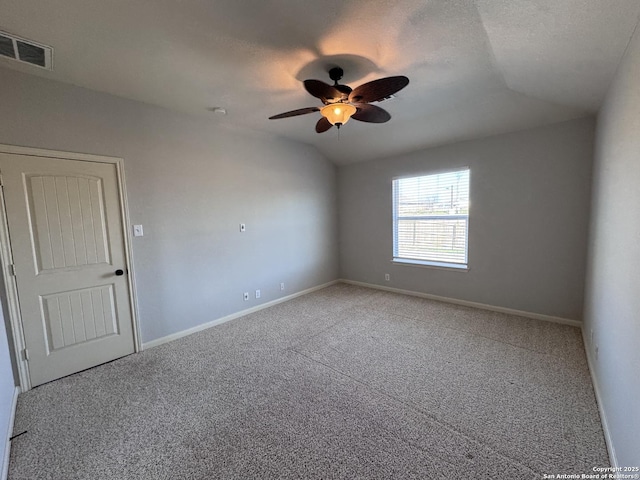 empty room featuring vaulted ceiling, carpet floors, ceiling fan, and a textured ceiling