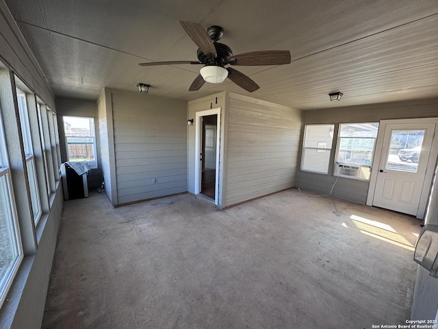 unfurnished sunroom featuring cooling unit and ceiling fan