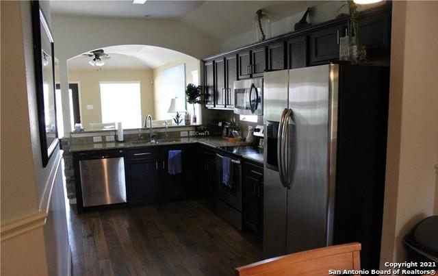 kitchen featuring sink, ceiling fan, stainless steel appliances, dark hardwood / wood-style floors, and vaulted ceiling