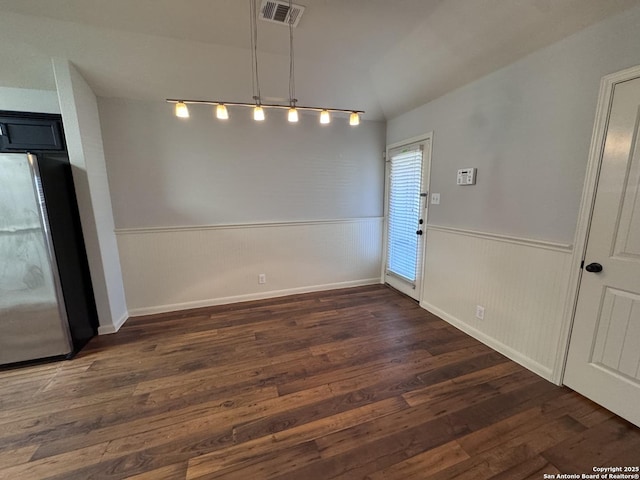 unfurnished dining area with vaulted ceiling and dark wood-type flooring