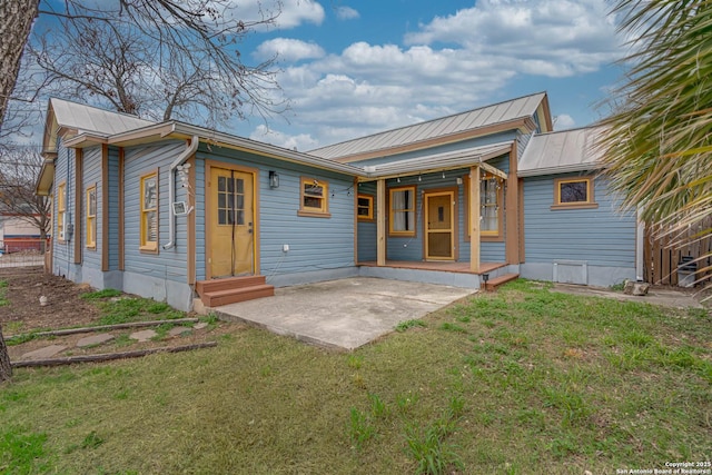 back of house with a patio and a lawn