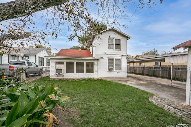 rear view of house featuring cooling unit and a lawn