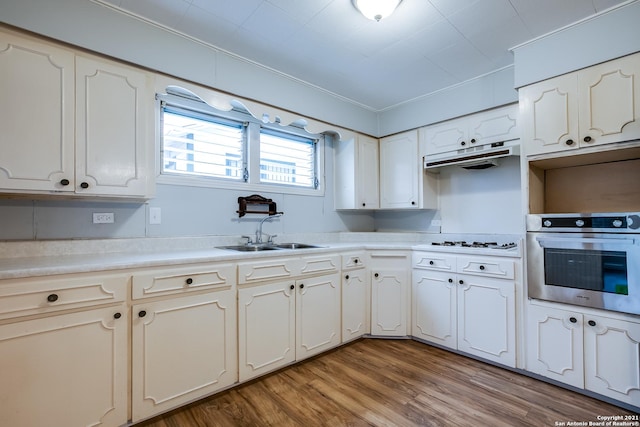 kitchen with sink, light hardwood / wood-style flooring, white gas stovetop, and oven