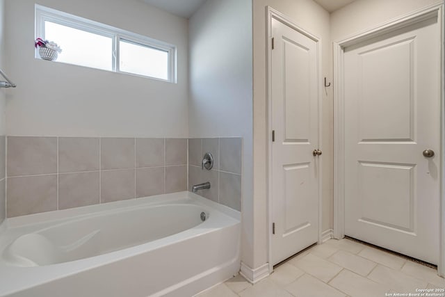 bathroom with tile patterned flooring and a bath