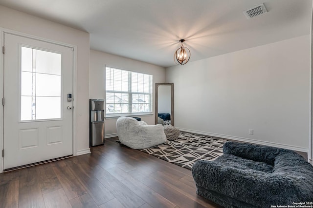 living area featuring an inviting chandelier and dark hardwood / wood-style flooring