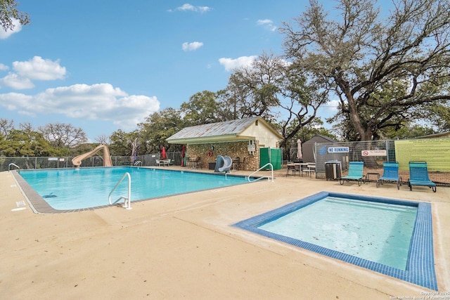 view of swimming pool with a patio and a water slide