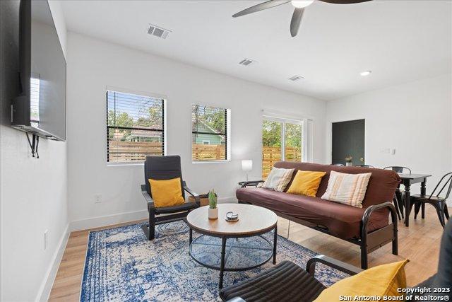 living room featuring ceiling fan and light hardwood / wood-style flooring