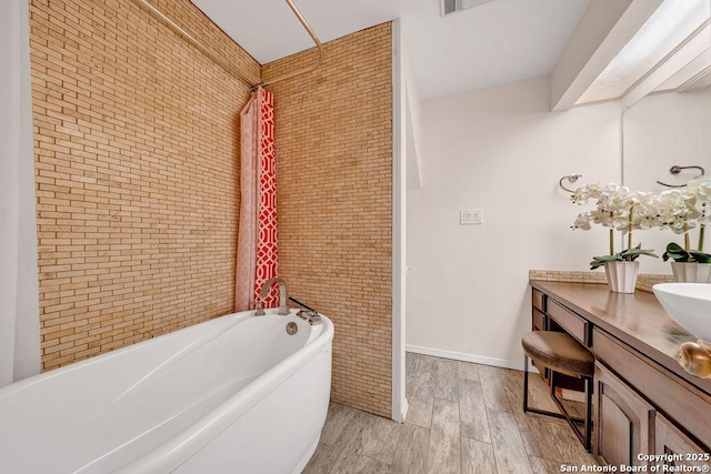 bathroom featuring hardwood / wood-style flooring, vanity, brick wall, and shower / tub combo