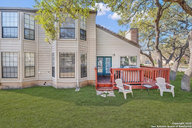 rear view of property with a wooden deck, a yard, and french doors