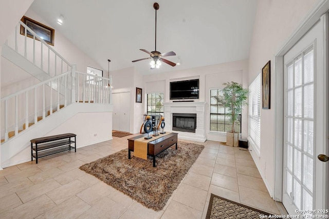 tiled living room featuring ceiling fan and high vaulted ceiling