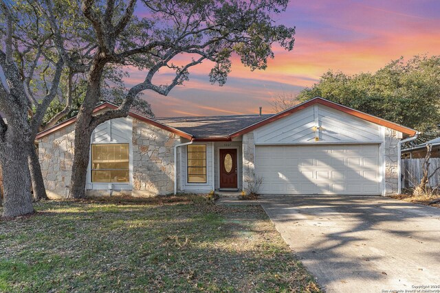 ranch-style house with a garage and a yard