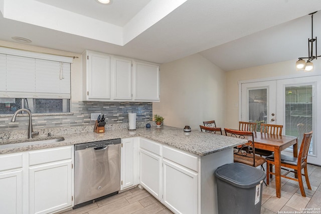 kitchen with sink, white cabinetry, decorative light fixtures, stainless steel dishwasher, and kitchen peninsula