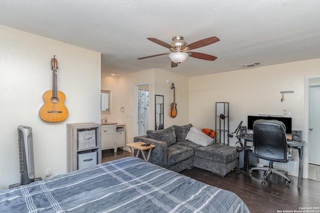 bedroom with ceiling fan, dark hardwood / wood-style floors, and a textured ceiling