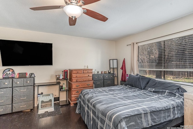 bedroom with ceiling fan, a textured ceiling, and dark hardwood / wood-style flooring