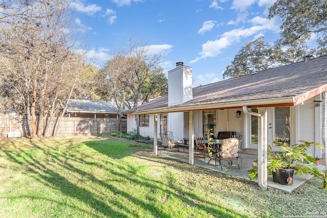 rear view of house with a patio and a lawn