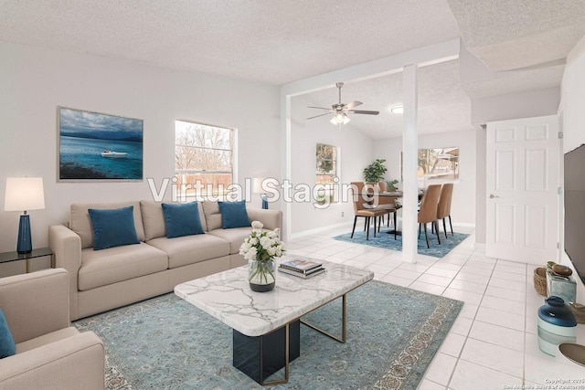 living room featuring tile patterned flooring, vaulted ceiling, ceiling fan, and a textured ceiling