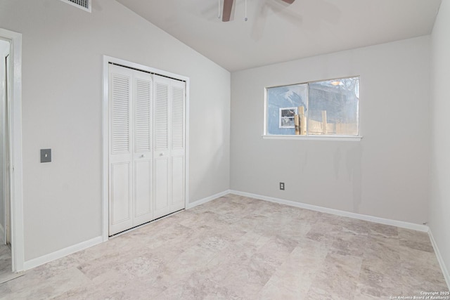 unfurnished bedroom with lofted ceiling, a closet, and ceiling fan