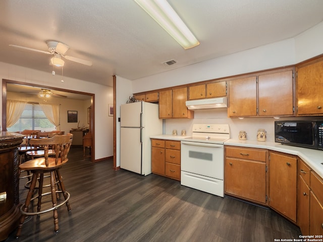 kitchen featuring ceiling fan, white appliances, dark hardwood / wood-style floors, and a textured ceiling