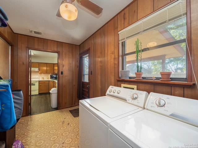 laundry area with ceiling fan, independent washer and dryer, and wooden walls