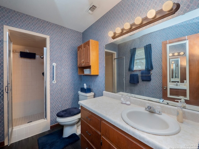 bathroom with vanity, toilet, an enclosed shower, and hardwood / wood-style floors